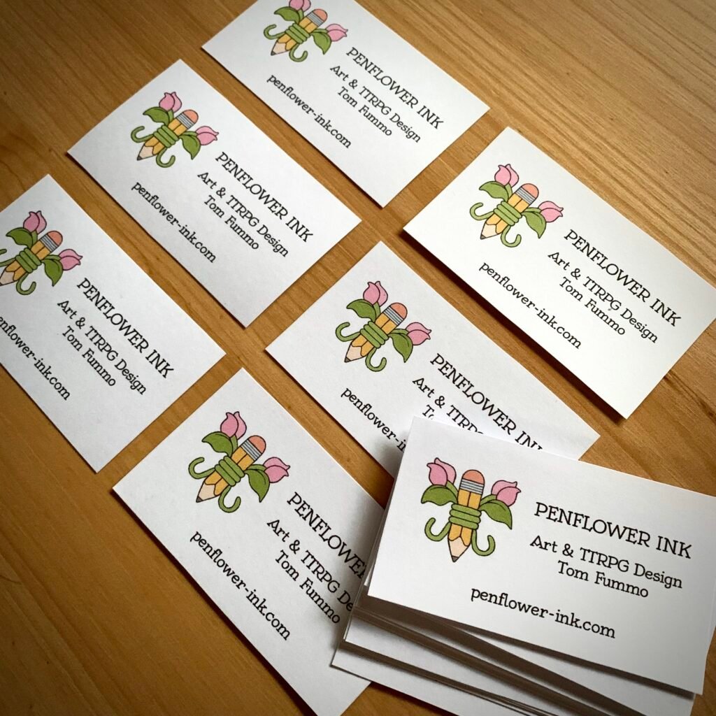 Photo of a collection of home-made business cards, featuring the Penflower Ink logo and website URL. Text reads: Art & TTRPG design, Tom Fummo.