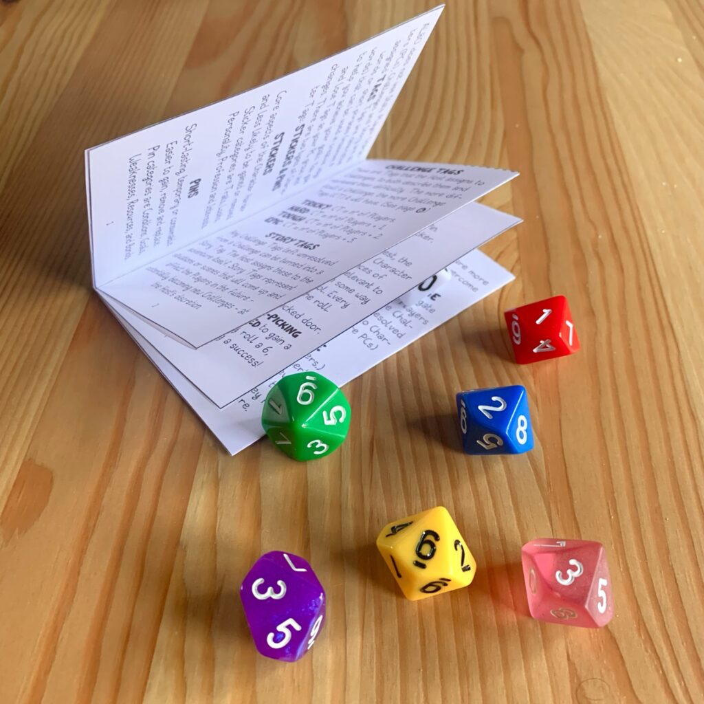 Photo of the printed and assembled Albo Pocket Version booklet, interior pages. Surrounded by colourful d10.