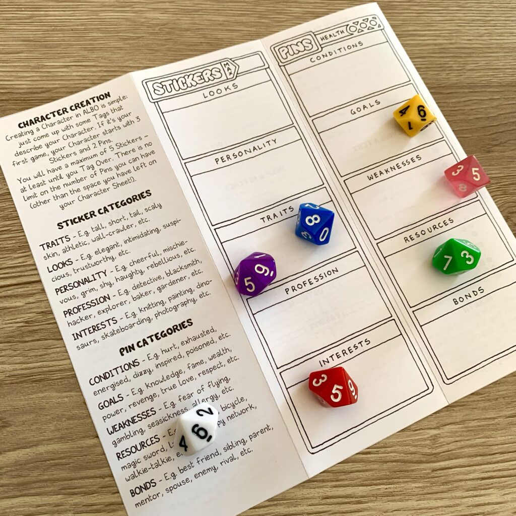 ALBO bookmark pamphlet, open, showing character creation rules and character sheet. Colourful d10 dice for decoration.