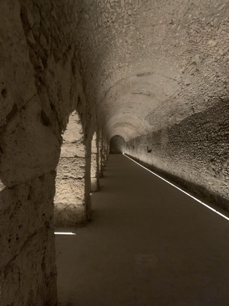 Criptoportico Forense - gallery view. The ancient roman stone brickwork is dimly lit.